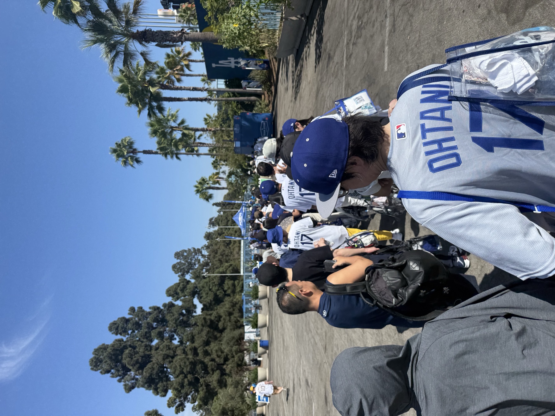 球迷穿著大谷翔平球衣，提著透明包排隊進入道奇球場